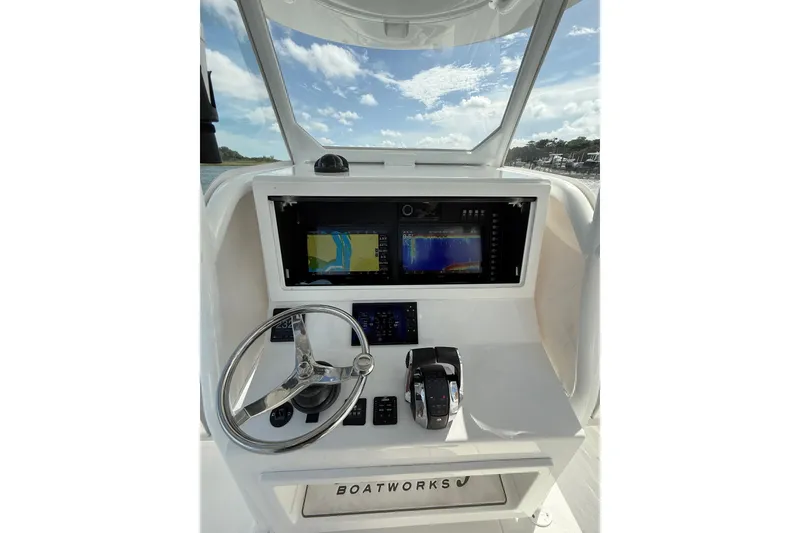 Slide: The Image of 2022 Onslow Bay 33 boat dashboard with navigation screens and steering wheel. - 7