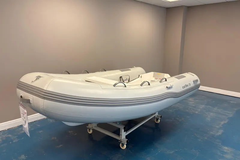 Slide: The Image of Inflatable Caribe L-10 boat displayed indoors with contact information and website. - 2