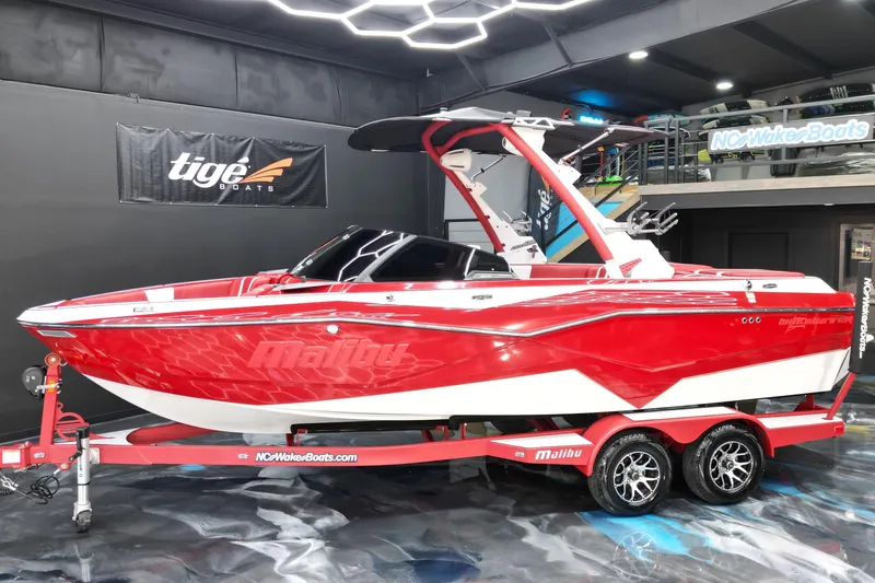 The Image of 2023 Malibu Wakesetter 22 LSV boat in vibrant red on display indoors. - 1