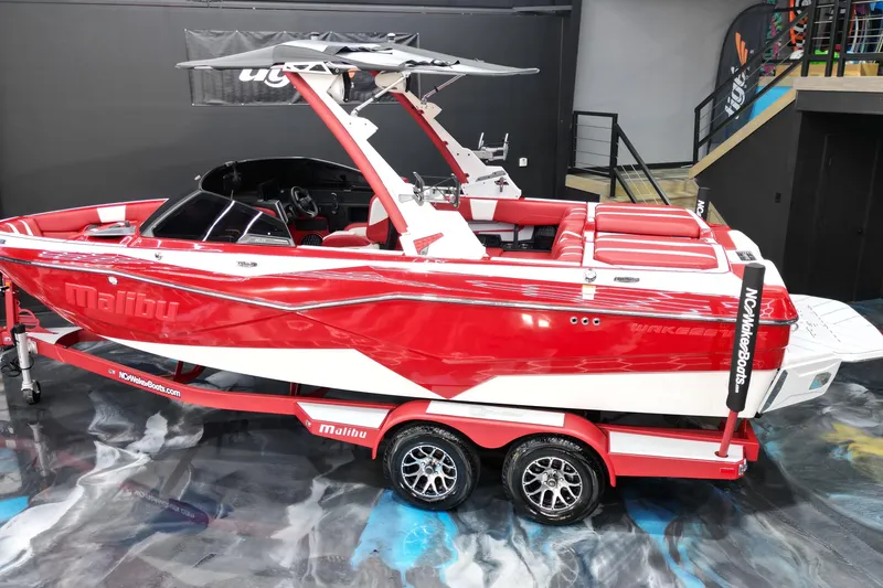 Slide: The Image of 2023 Malibu Wakesetter 22 LSV boat in vibrant red and white on display indoors. - 13
