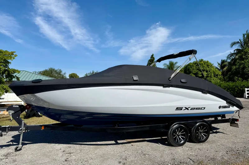 Slide: The Image of 2024 Yamaha Boats SX250 on trailer, covered, parked outdoors. - 30