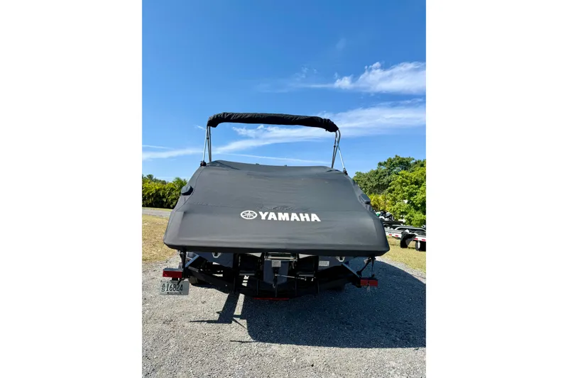 Slide: The Image of 2024 Yamaha Boats SX250 with cover, parked outdoors under clear blue sky. - 31