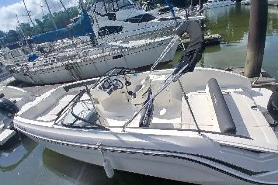 Slide: The Image of 2023 Bayliner DX 2200 boat docked at marina, featuring sleek design and spacious seating. - 4