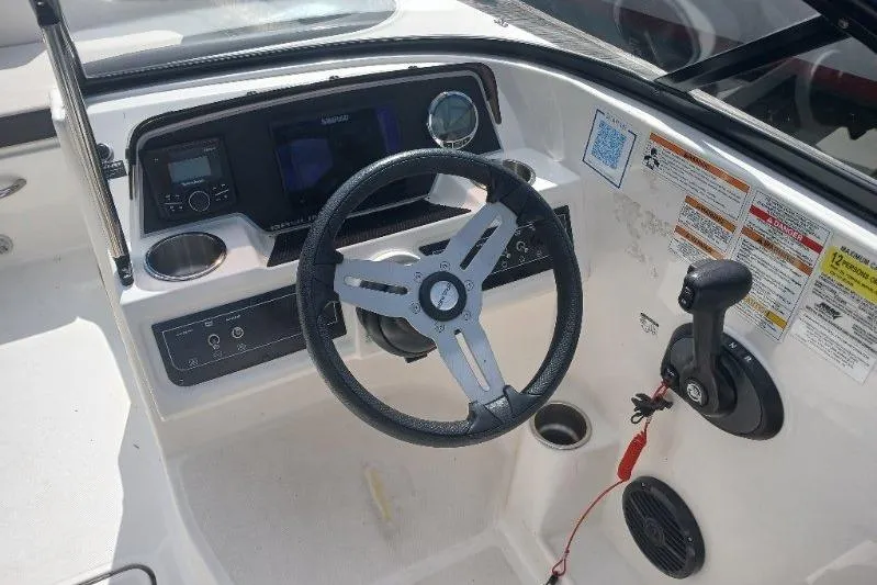 Slide: The Image of 2023 Bayliner DX 2200 boat dashboard with steering wheel and control panel. - 5