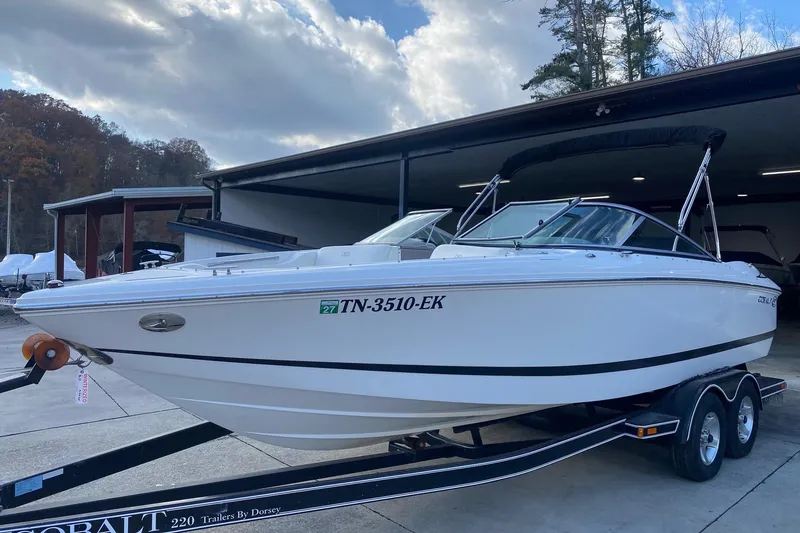Slide: The Image of 2004 Cobalt 220 boat on trailer, parked outdoors under cloudy sky. - 3