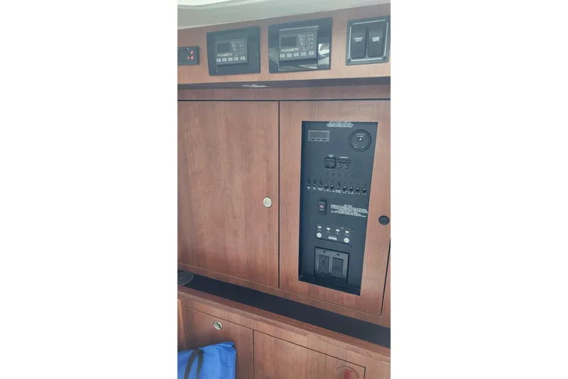 Slide: The Image of 2026 Pursuit DC 326 Dual Console electrical panel with wooden finish and control switches. - 13