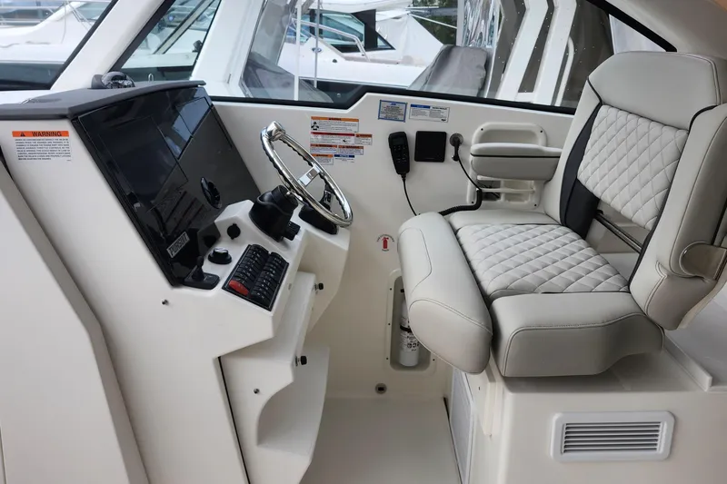 Slide: The Image of 2026 Pursuit DC 326 Dual Console helm with modern controls and luxurious seating. - 17