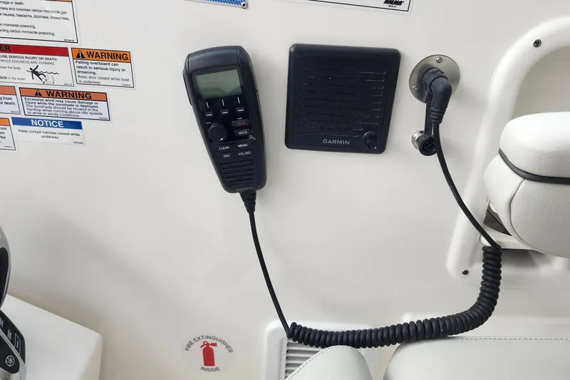 Slide: The Image of 2026 Pursuit DC 326 Dual Console boat interior with Garmin radio and safety warnings. - 19