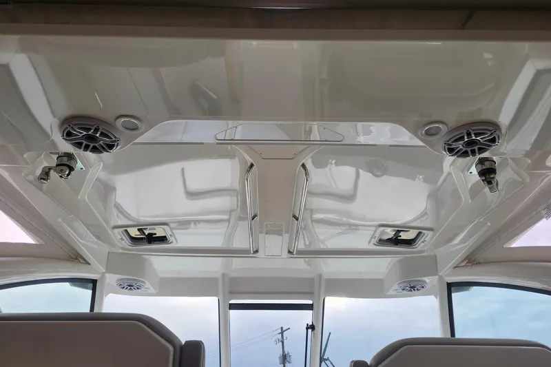 Slide: The Image of 2026 Pursuit DC 326 Dual Console boat interior ceiling with speakers and hatches. - 20