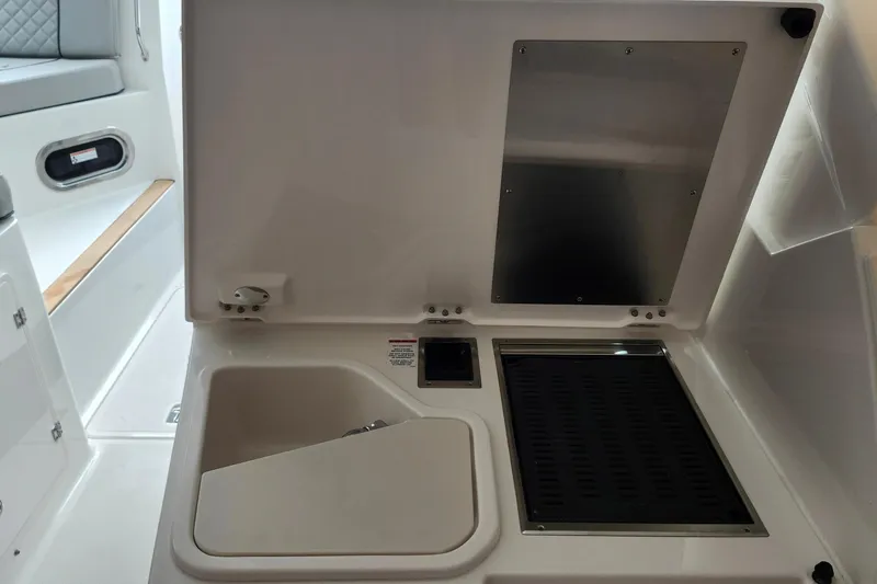 Slide: The Image of Interior view of 2026 Pursuit DC 326 Dual Console boat, featuring a compact sink and grill. - 25