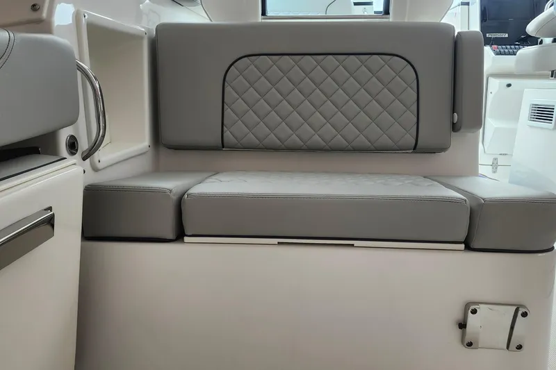 Slide: The Image of 2026 Pursuit DC 326 Dual Console boat interior with gray cushioned seating. - 27