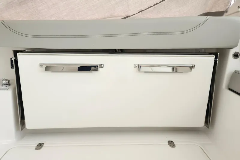 Slide: The Image of 2026 Pursuit DC 326 Dual Console boat storage compartment with sleek handles. - 31
