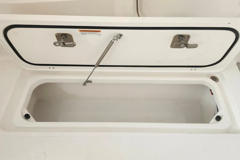 Slide: The Image of Open storage compartment on 2026 Pursuit DC 326 Dual Console boat. - 32