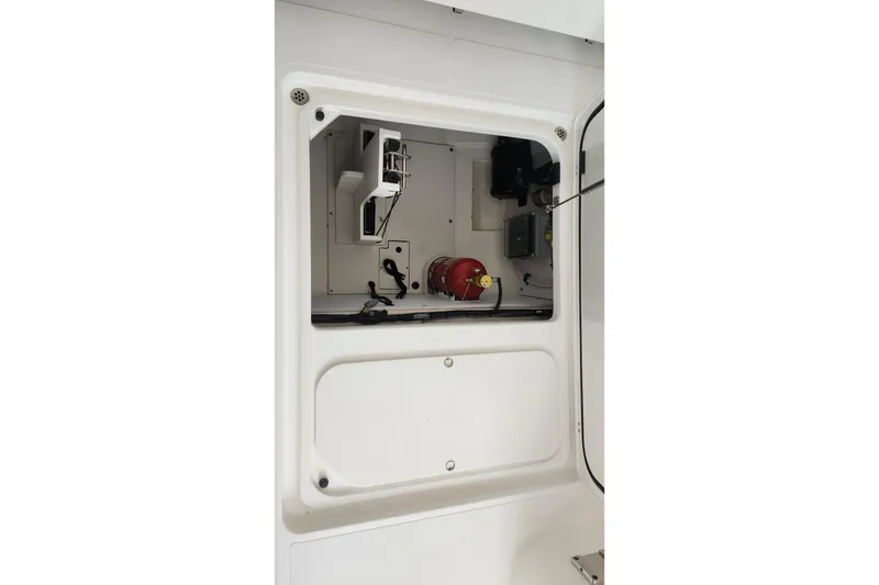 Slide: The Image of 2026 Pursuit DC 326 Dual Console interior compartment with equipment and wiring. - 33