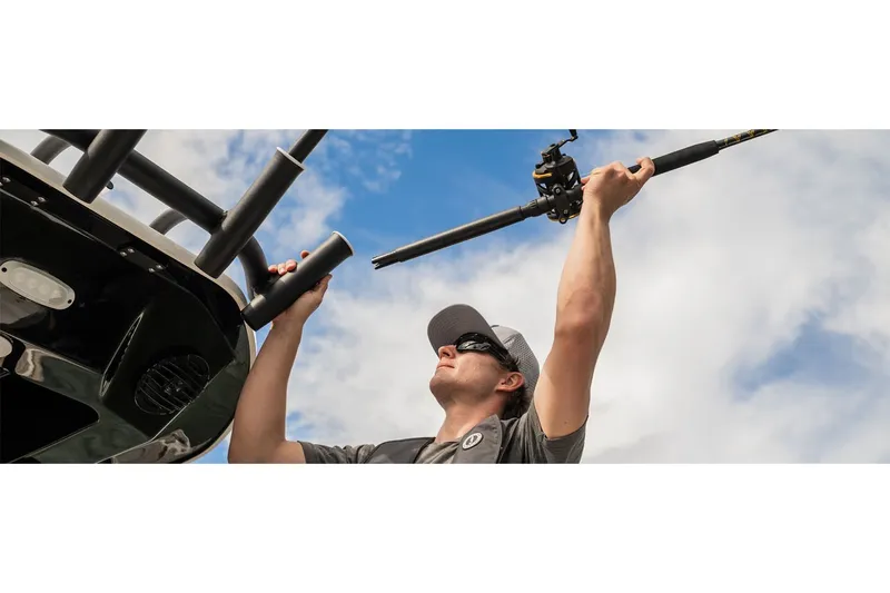 Slide: The Image of Man placing fishing rod on Yamaha 222 FSH Sport E boat, 2025 model, under blue sky. - 7