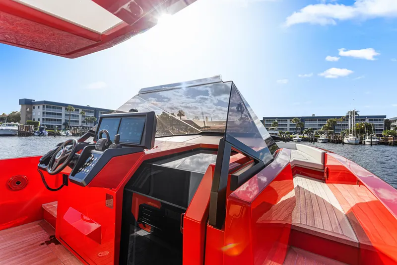 Slide: The Image of Red 2021 Wally 48 yacht cockpit with modern controls, docked near waterfront buildings. - 11