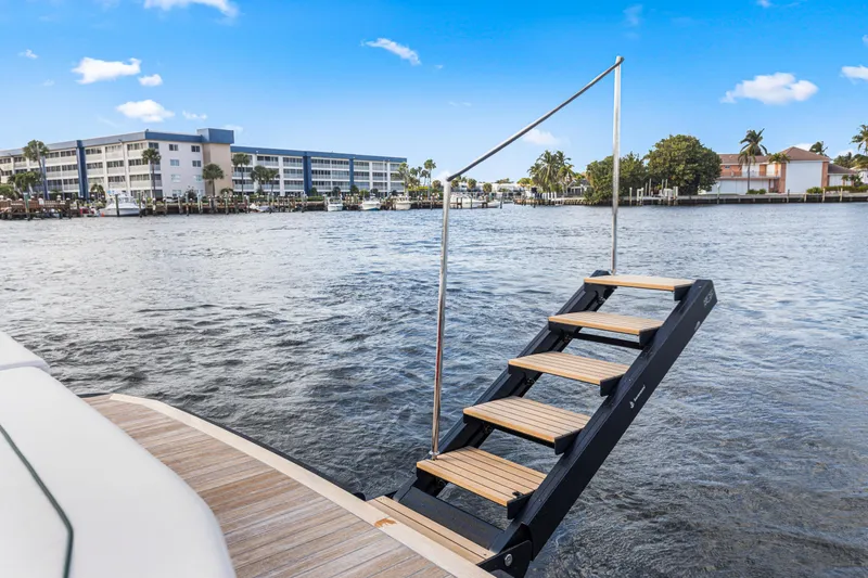 Slide: The Image of Staircase on Wally 48 yacht, 2021 model, overlooking waterfront buildings and clear blue sky. - 35