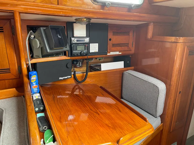 Slide: The Image of 1985 Chuck Paine Intrepid 40 Center Cockpit interior with navigation equipment and wooden cabinetry. - 10