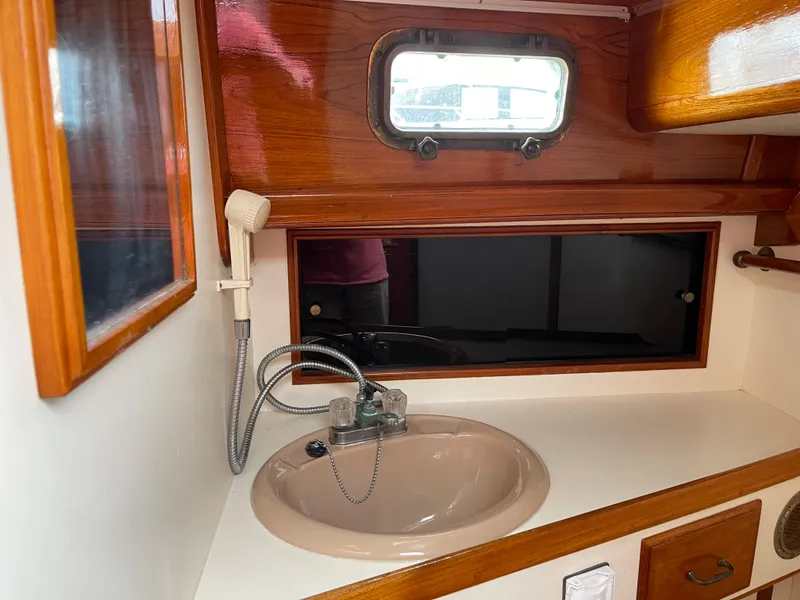 Slide: The Image of 1985 Chuck Paine Intrepid 40 yacht bathroom with sink and wooden cabinetry. - 18