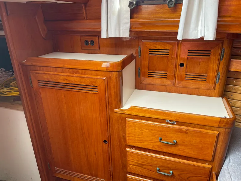 Slide: The Image of 1985 Chuck Paine Intrepid 40 Center Cockpit interior with wooden cabinetry and drawers. - 19