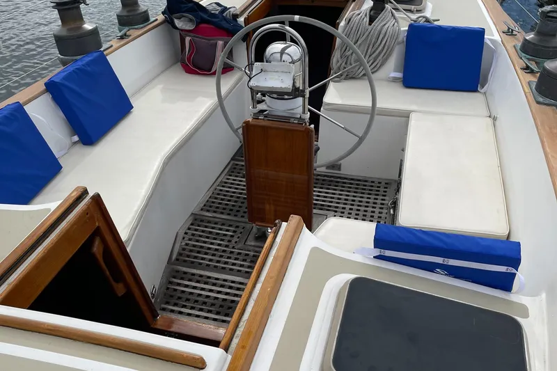 Slide: The Image of 1985 Chuck Paine Intrepid 40 Center Cockpit with blue cushions and wooden steering wheel. - 21