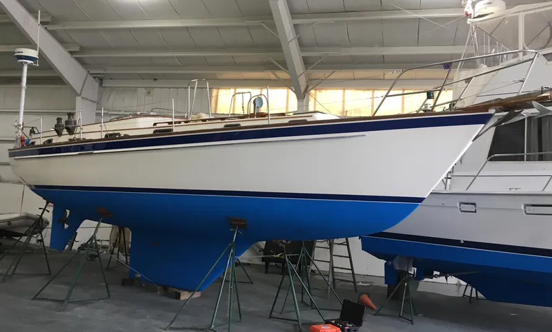 Slide: The Image of 1985 Chuck Paine Intrepid 40 Center Cockpit sailboat in indoor storage, blue hull. - 37