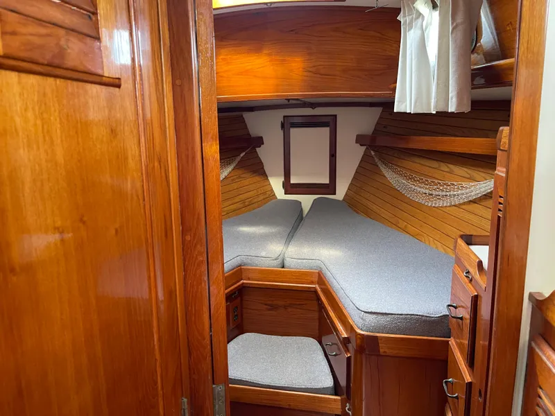 Slide: The Image of 1985 Chuck Paine Intrepid 40 Center Cockpit interior with wooden finish and cozy sleeping area. - 4