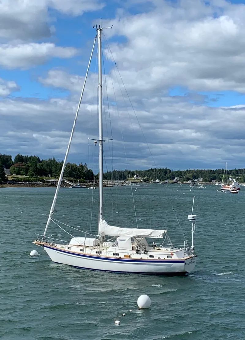 Slide: The Image of 1985 Chuck Paine Intrepid 40 Center Cockpit sailboat on a calm sea under cloudy skies. - 40