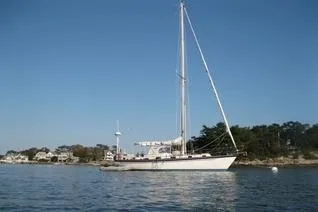 Slide: The Image of 1985 Chuck Paine Intrepid 40 Center Cockpit sailboat on calm water, clear sky background. - 46