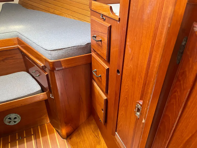 Slide: The Image of 1985 Chuck Paine Intrepid 40 Center Cockpit interior with wooden cabinetry and cushioned seating. - 5