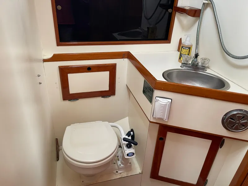 Slide: The Image of 1985 Chuck Paine Intrepid 40 yacht bathroom with toilet, sink, and wooden accents. - 6