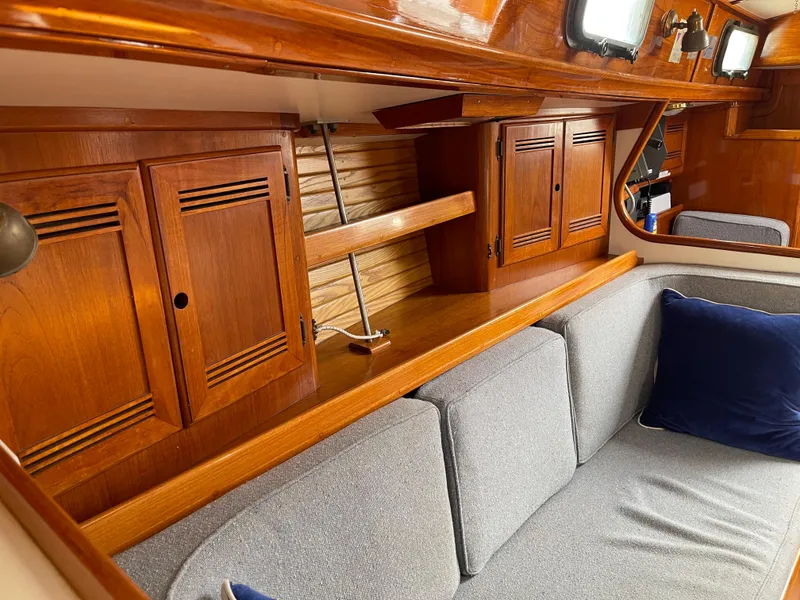 Slide: The Image of Interior of 1985 Chuck Paine Intrepid 40 yacht with wooden cabinets and gray seating. - 7