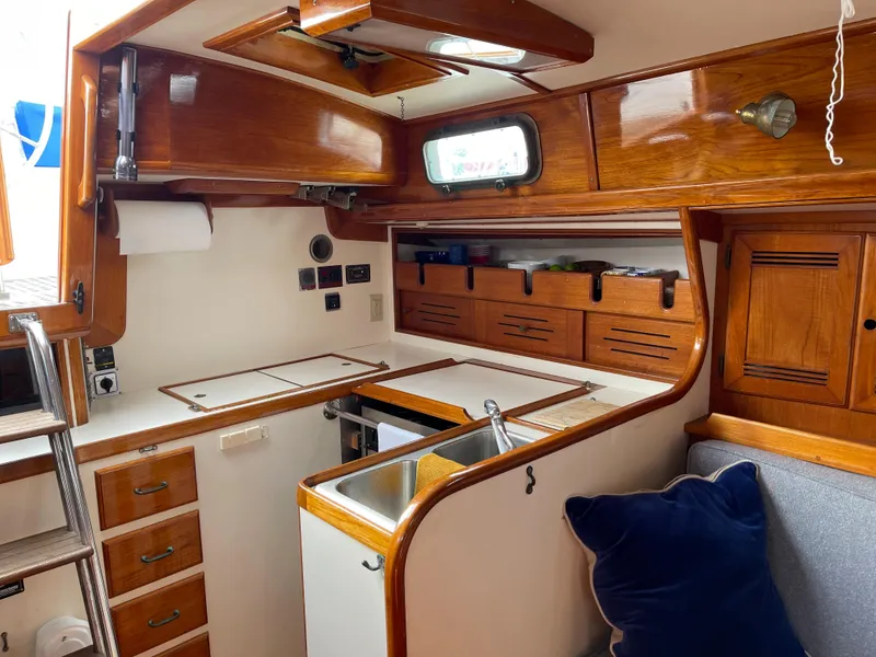 Slide: The Image of Interior of 1985 Chuck Paine Intrepid 40 Center Cockpit with wooden cabinetry and compact kitchen. - 8