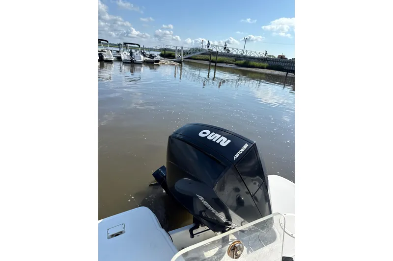 Slide: The Image of Outboard motor on Trophy CC24 boat, 2023 model, docked by a calm marina. - 9