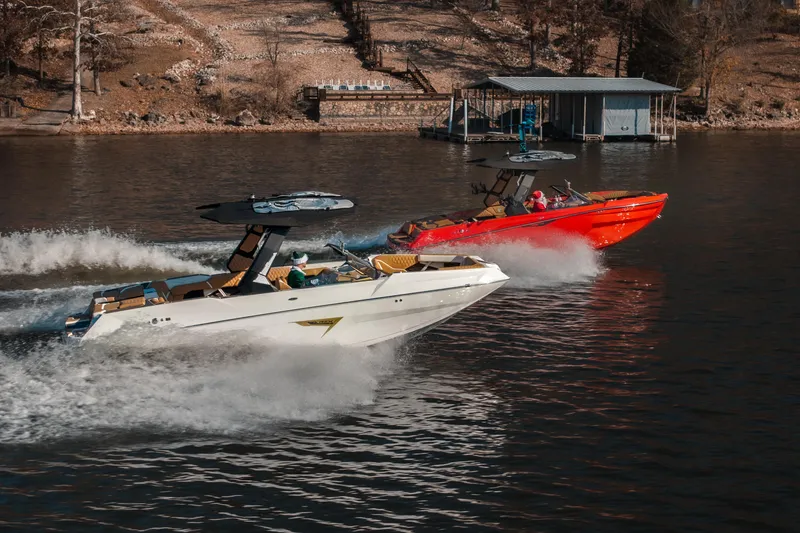 The Image of 2026 Tigé 24RZX boats racing on a lake, showcasing sleek design and performance. - 1