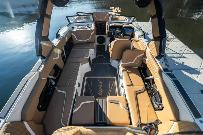 Slide: The Image of 2026 Tigé 24RZX boat interior with luxurious tan seating and modern dashboard on water. - 7