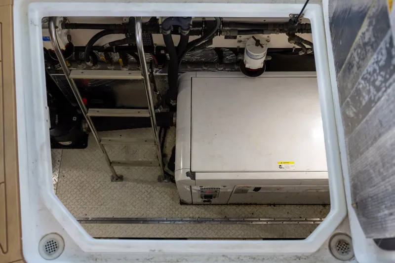 Slide: The Image of Engine compartment of 2013 Cruisers Yachts 540 Sports Coupe with visible machinery and ladder. - 32