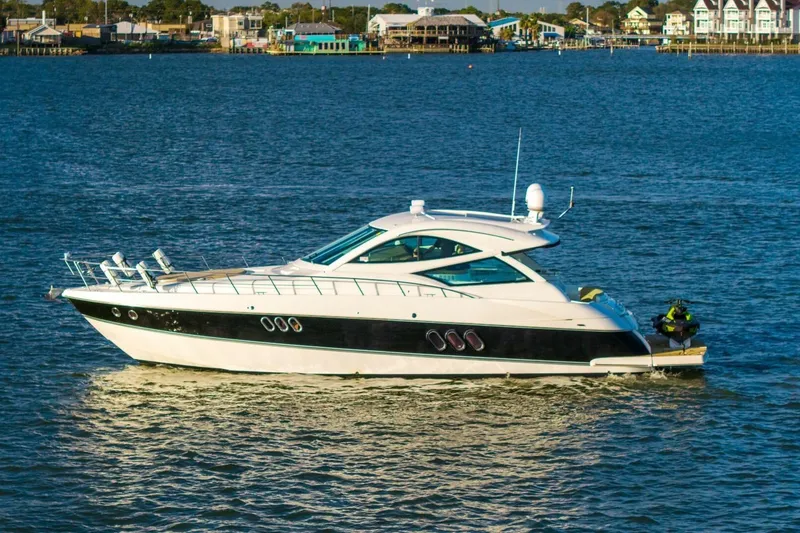 The Image of 2013 Cruisers Yachts 540 Sports Coupe on calm water, coastal background. - 2