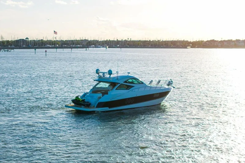 Slide: The Image of 2013 Cruisers Yachts 540 Sports Coupe on serene water at sunset. - 45