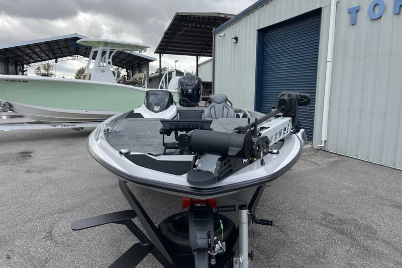 Slide: The Image of 2026 Skeeter ZXR21 SE boat parked outside a warehouse on a cloudy day. - 2