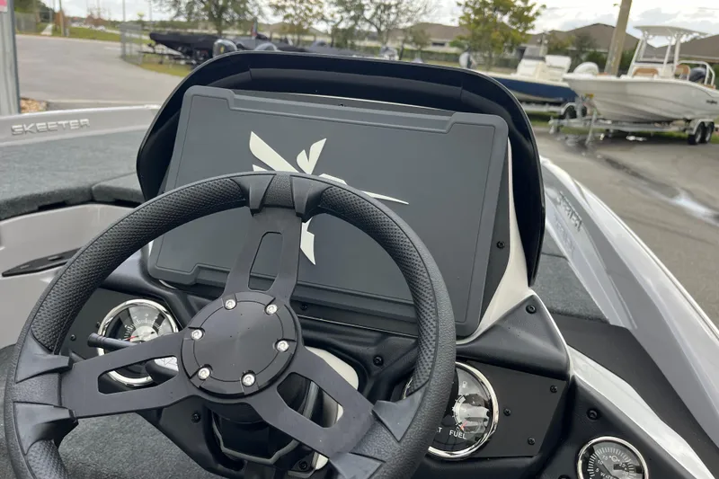 Slide: The Image of Steering wheel and dashboard of 2026 Skeeter ZXR21 SE boat, featuring modern controls. - 9