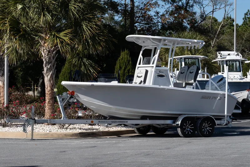 Slide: The Image of 2026 Sea Pro 202 Center Console boat on trailer, parked near palm trees. - 2