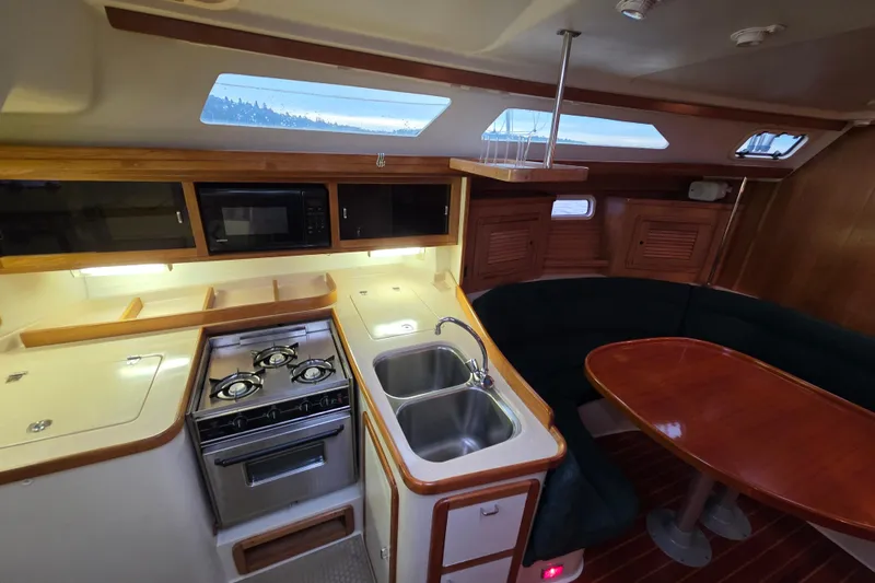 Slide: The Image of Interior of a 1998 Catalina 42 MkII yacht with kitchen and dining area. - 12