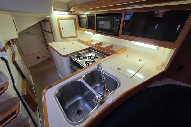 Slide: The Image of 1998 Catalina 42 MkII yacht kitchen with dual sink, stove, and microwave. - 13