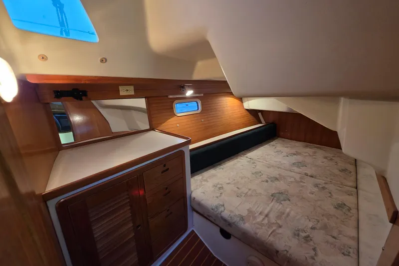 Slide: The Image of 1998 Catalina 42 MkII yacht cabin with bed, wooden cabinetry, and small window. - 14