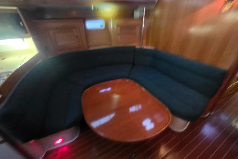 Slide: The Image of Interior of 1998 Catalina 42 MkII yacht with wooden table and cushioned seating. - 19