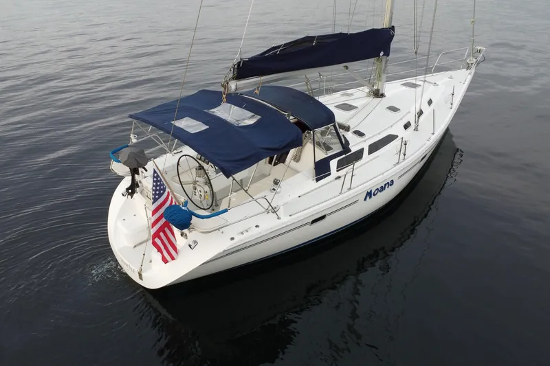 Slide: The Image of 1998 Catalina 42 MkII sailboat with blue canopy on calm water. - 3