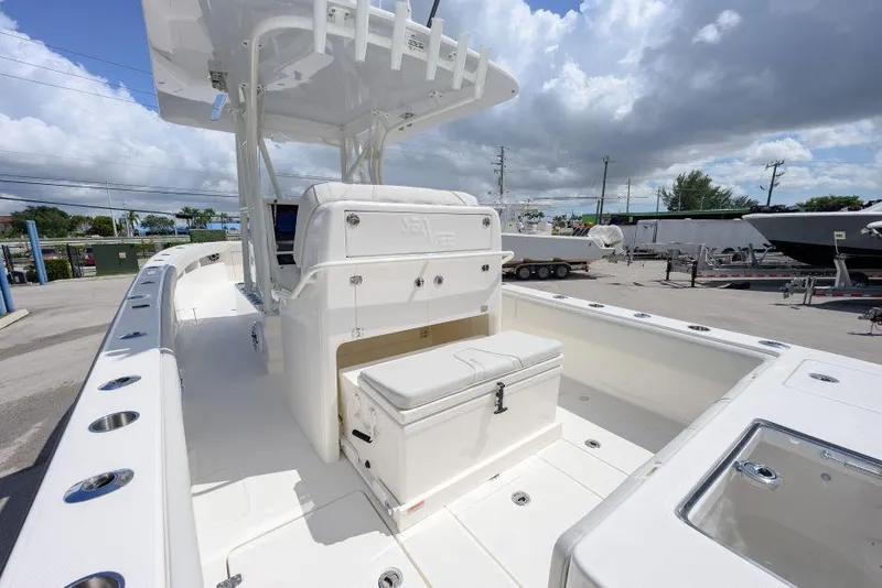 Slide: The Image of 2025 SeaVee 320B boat interior with seating and storage, under a cloudy sky. - 11