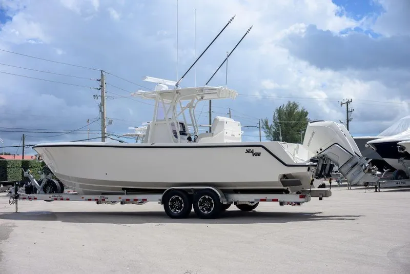 Slide: The Image of 2025 SeaVee 320B boat on trailer under cloudy sky, side view. - 3