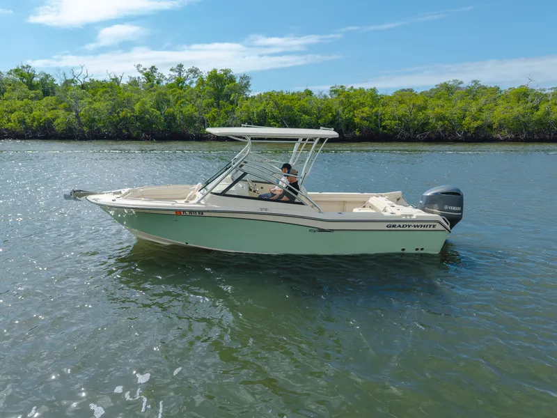 Slide: The Image of 2018 Grady-White Freedom 255 boat cruising on a calm river with lush greenery. - 10